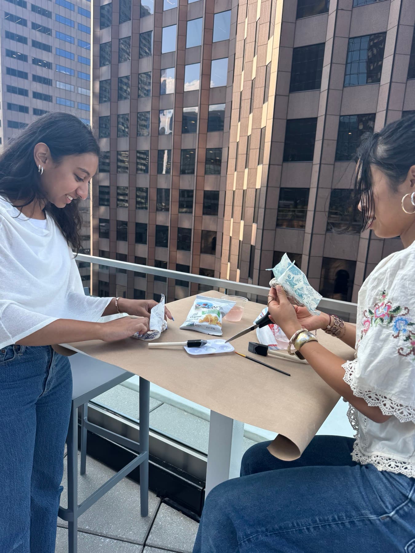 Experience manager leading a hands-on craft workshop with a tenant on an office terrace